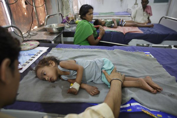 A man comforted his sick daughter at a hospital in Muzaffarpur, India, in 2013.