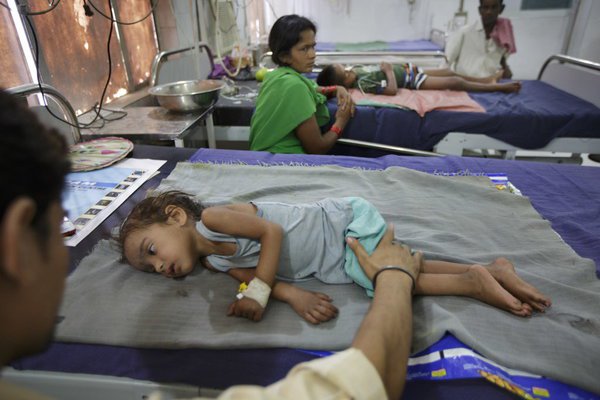 A man comforted his sick daughter at a hospital in Muzaffarpur, India, in 2013. 