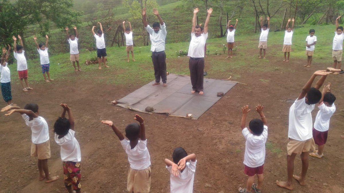 School children doing yoga with their teachers leading them on